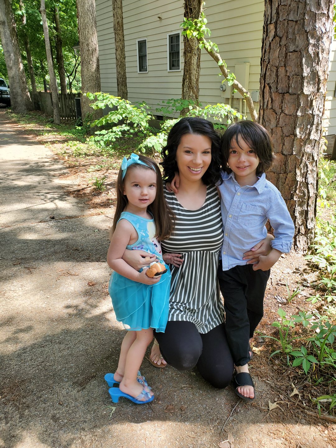 Troy’s wife and two children smiling outdoors